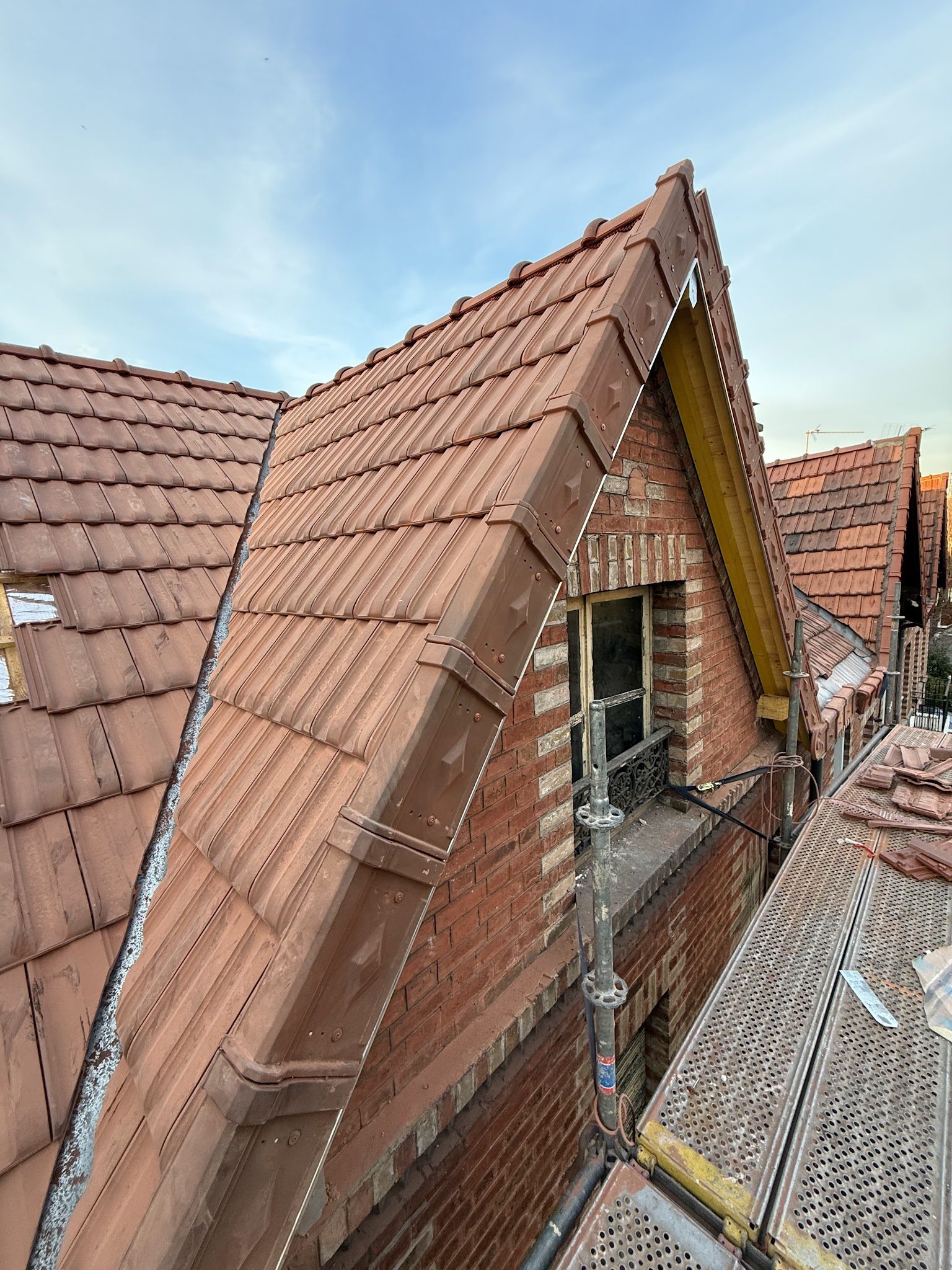 Lucarne en brique et toiture en tuiles refaites, vue depuis l'échafaudage