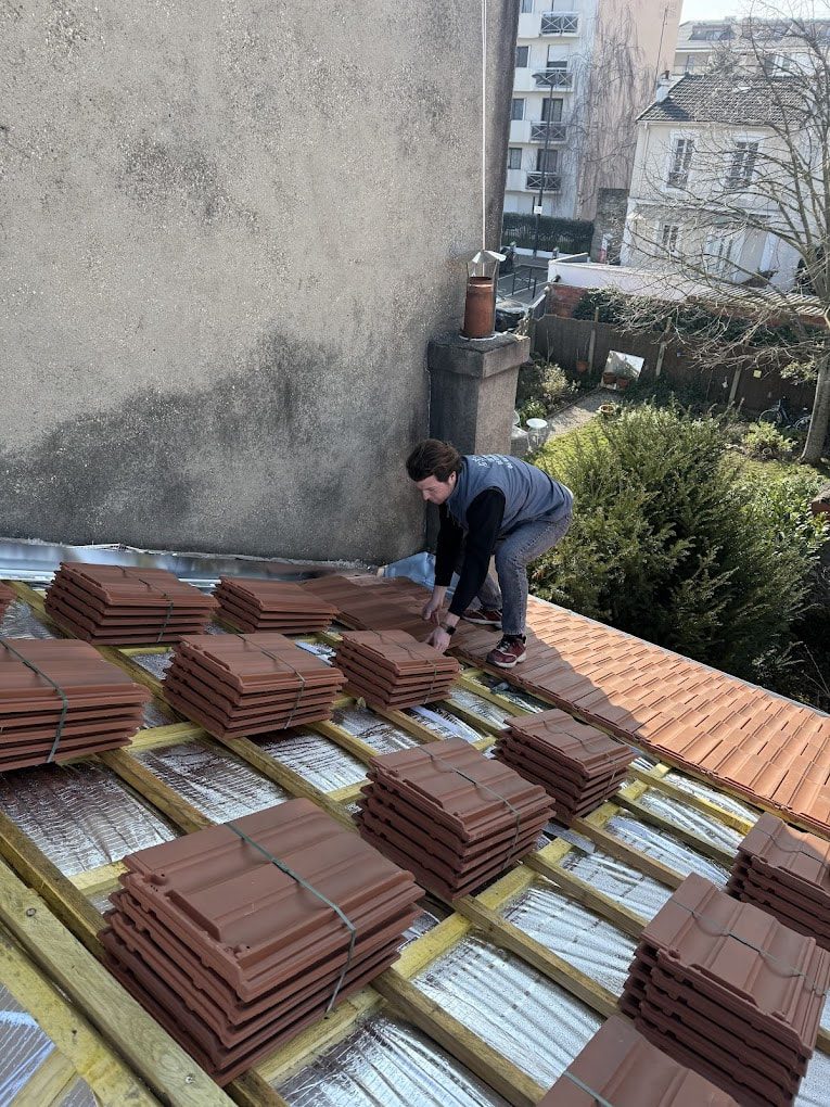 Couvreur répartissant les paquets de tuiles sur le versant