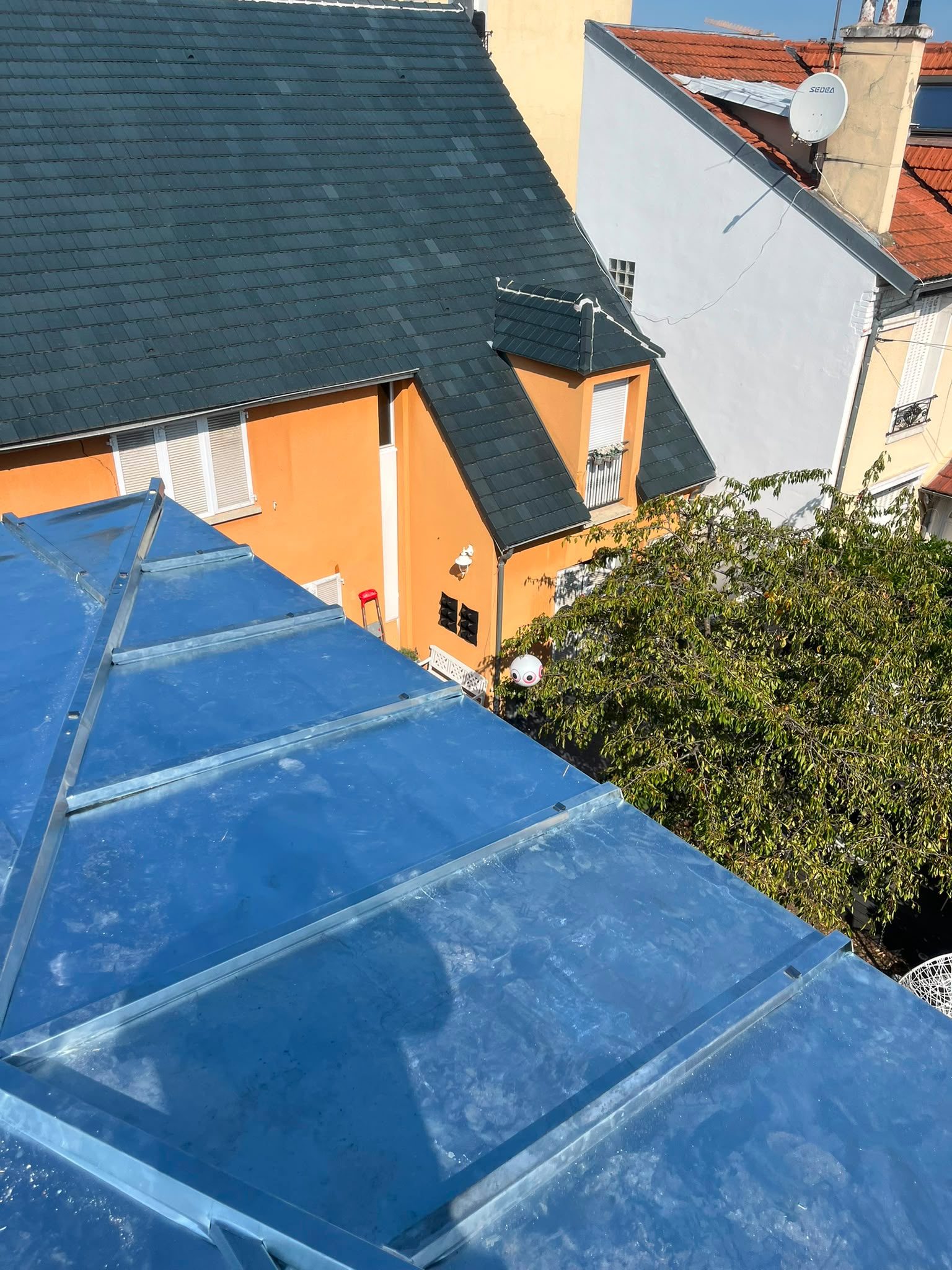 Couverture en zinc à tasseaux devant une toiture en ardoise